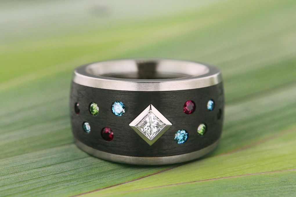 Damenring in Weissgold 750-Karbon, mit 1 Princess Diamant, und grünen und blauen Brillanten TW vs, und Rubinen, Breite 14.0mm 